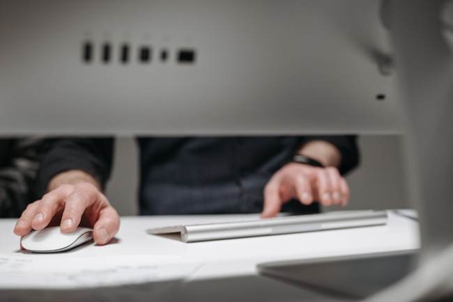 Zu sehen sind Hände, die eine Computer-Tastatur bedienen. Ist hier ein Hacker aktiv und startet Cyberangriffe 2023? Bild: Pexels/Pavel Danilyuk