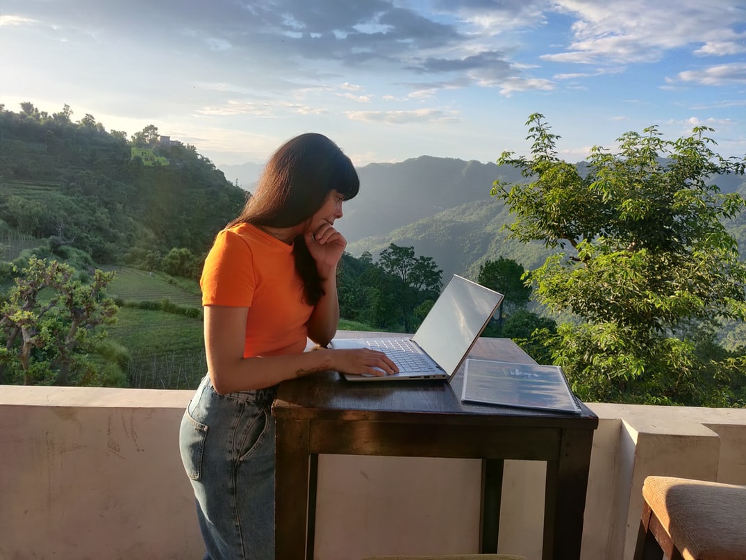 Eine Frau arbeitet auf ihrer Terrasse an ihrem Laptop. Themen sind Remote Work, VPN und Zero Trust Network Access
