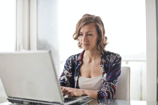 Eine Frau sitzt am Laptop und bucht ein Hotel. Sie muss wegen booking.com Phishing vorsichtig sein. Bild: Pexels/Andrea Piacquadio
