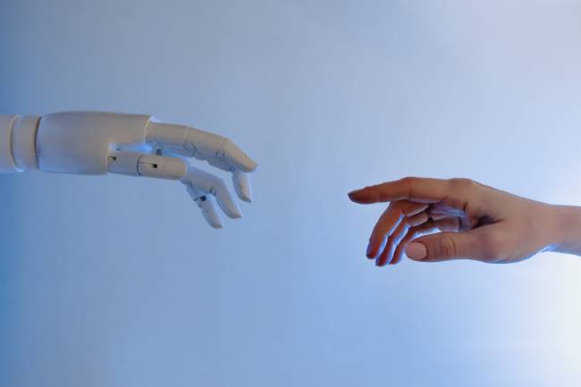 Eine Roboterhand und eine menschliche Hand berühren sich fast mit den Zeigefingern. Es geht um Künstliche Intelligenz, die positiv genutzt wird. Bild: Pexels/Tara Winstead