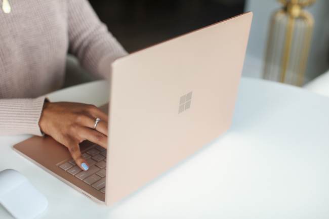 Hände bedienen einen Surface-Laptop. Es geht um die Frage, wie lange kann man Windows 10 noch nutzen. Bild: Unsplash/Surface